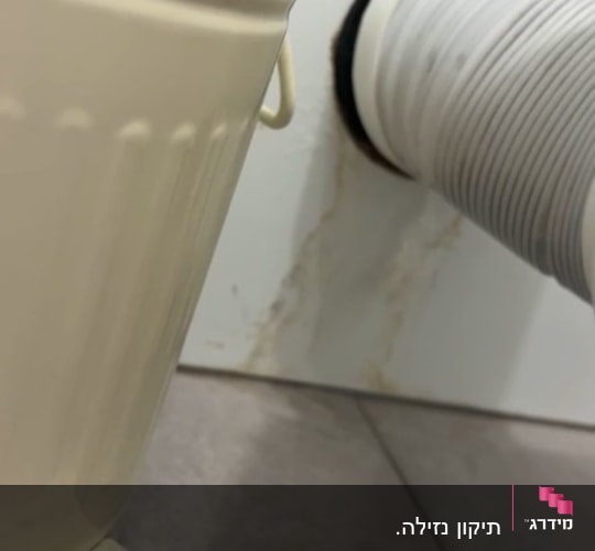 צינור מחובר לקיר עם סימני רטיבות